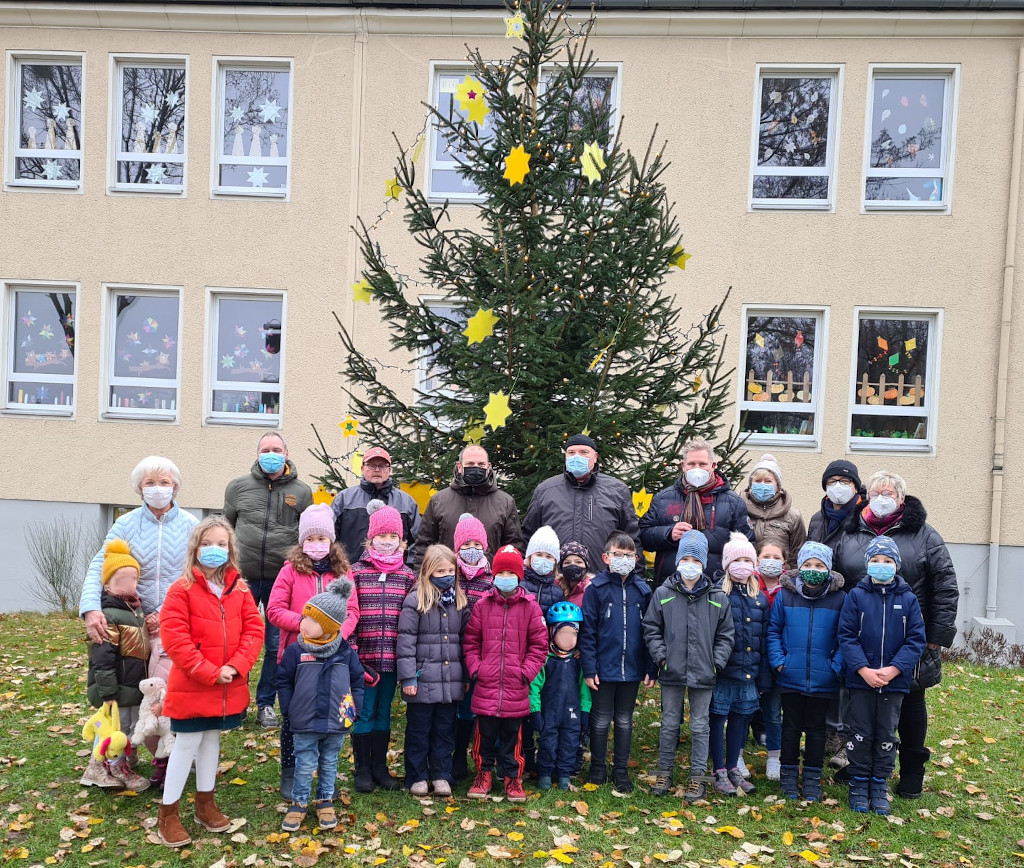 Stolze Kinder vor dem Baum